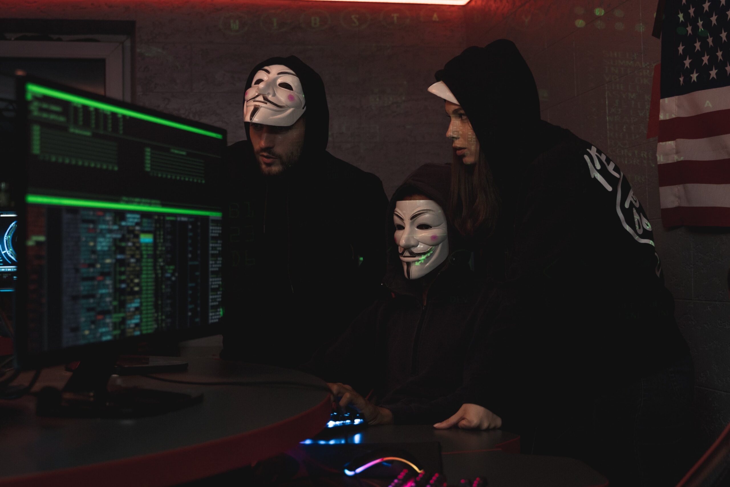 Picture showcasing hackers in the background of computer desktops with green lines of code